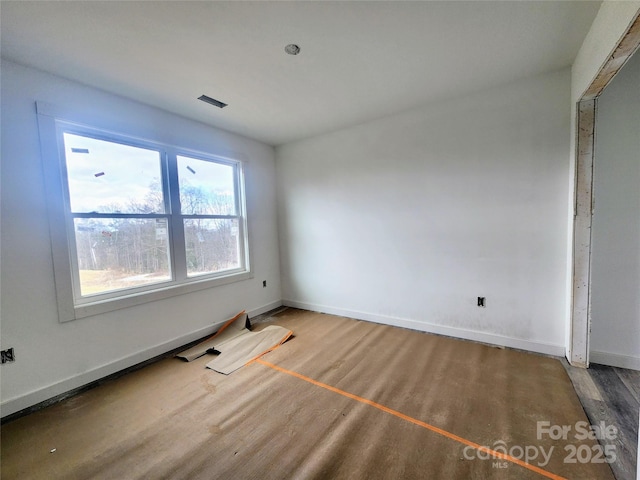 spare room featuring wood finished floors and baseboards