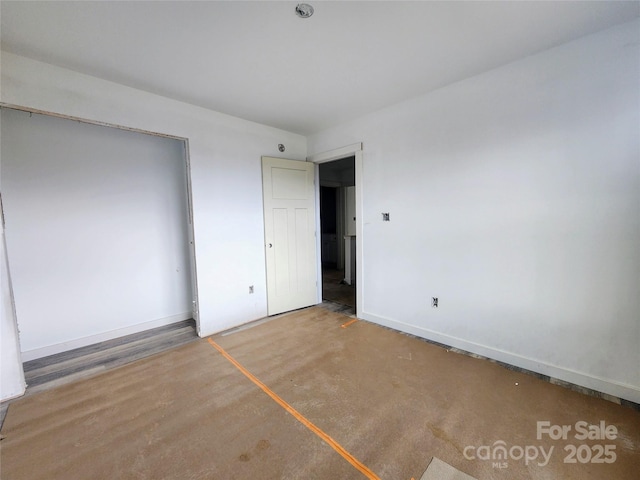 unfurnished bedroom featuring concrete flooring and baseboards