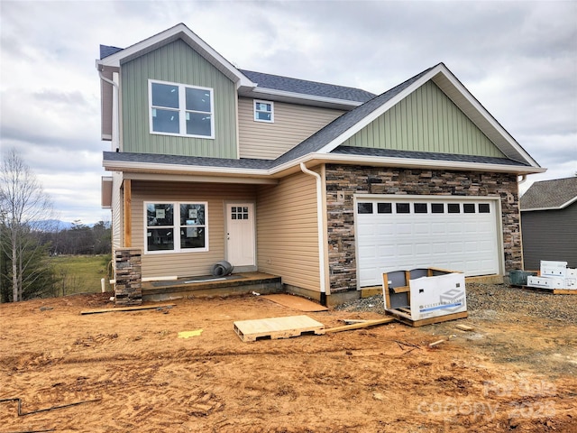 craftsman inspired home featuring a garage, stone siding, roof with shingles, and board and batten siding