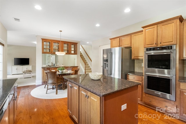 kitchen with light wood finished floors, recessed lighting, appliances with stainless steel finishes, and a center island