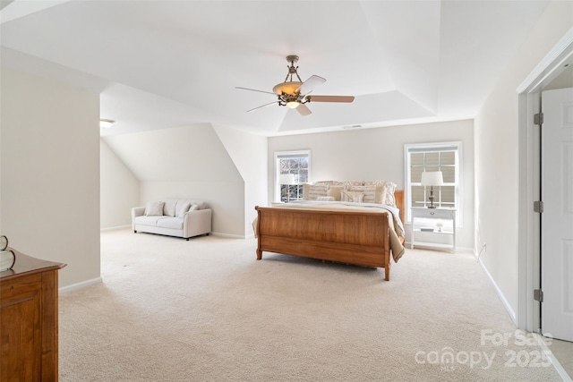 bedroom featuring visible vents, baseboards, a tray ceiling, carpet floors, and a ceiling fan