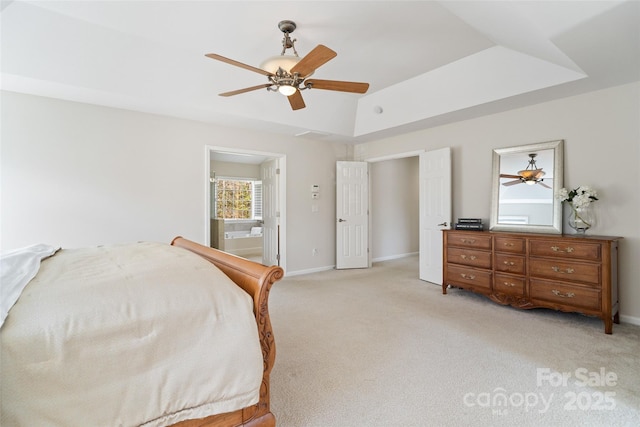 bedroom with light colored carpet, baseboards, and a tray ceiling