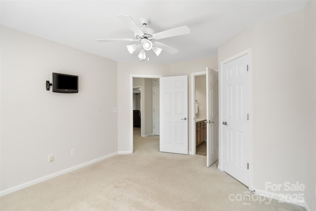 unfurnished bedroom featuring connected bathroom, baseboards, light colored carpet, and a ceiling fan