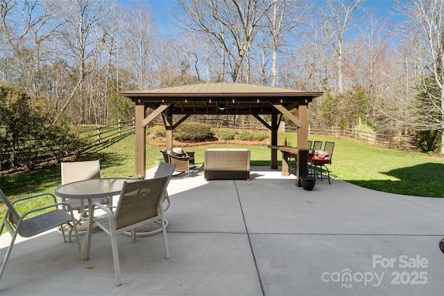 view of patio featuring a gazebo, outdoor dining space, and fence