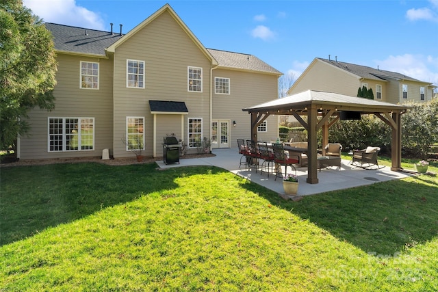 back of property with a lawn, an outdoor living space, a gazebo, french doors, and a patio area