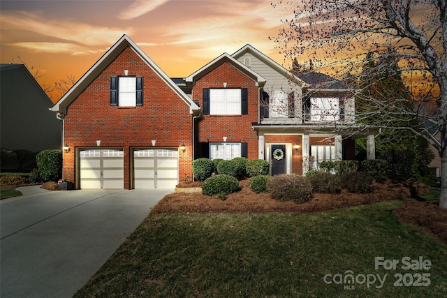 view of front facade with driveway, brick siding, an attached garage, and a front yard