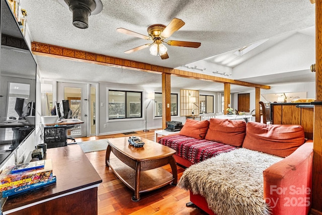 living room featuring lofted ceiling, ceiling fan, a textured ceiling, and hardwood / wood-style flooring