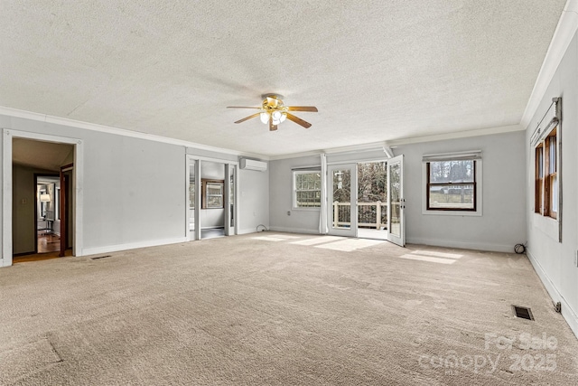 carpeted empty room with ceiling fan, a textured ceiling, visible vents, an AC wall unit, and ornamental molding