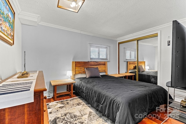 bedroom featuring a closet, ornamental molding, and wood finished floors