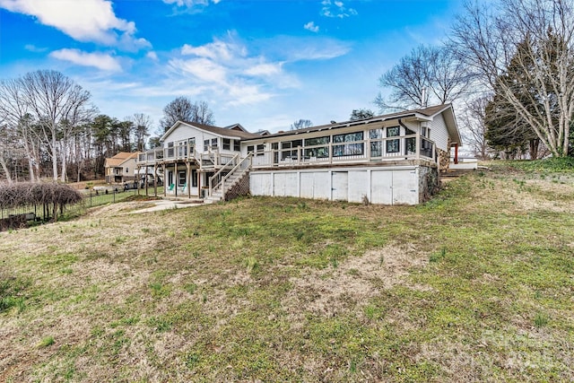 back of house featuring stairs, a yard, and a deck