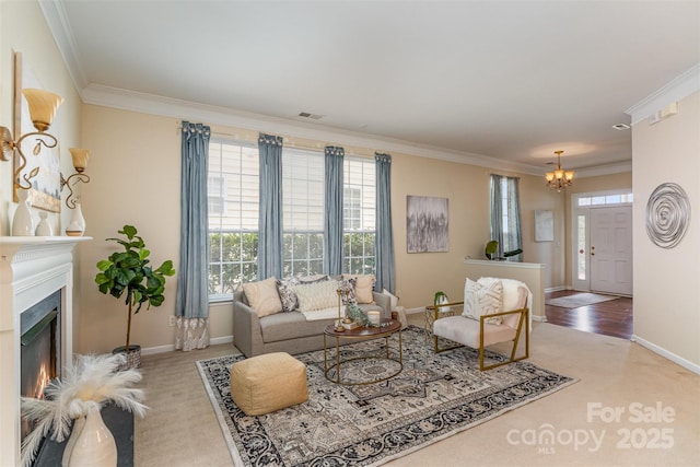 living room featuring visible vents, baseboards, a lit fireplace, ornamental molding, and an inviting chandelier