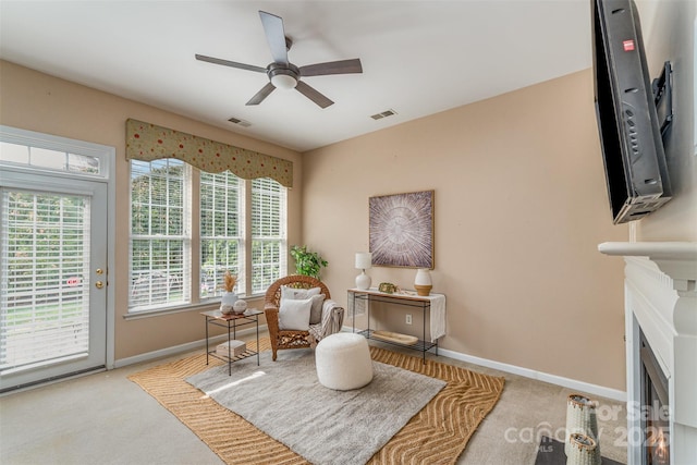 living area with visible vents, baseboards, a healthy amount of sunlight, and ceiling fan