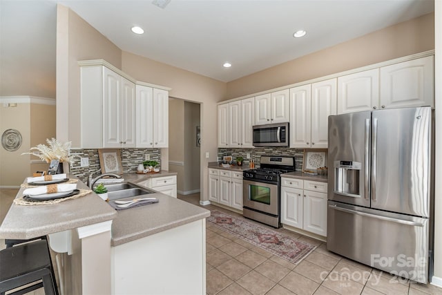 kitchen featuring tasteful backsplash, white cabinetry, appliances with stainless steel finishes, a peninsula, and light tile patterned flooring