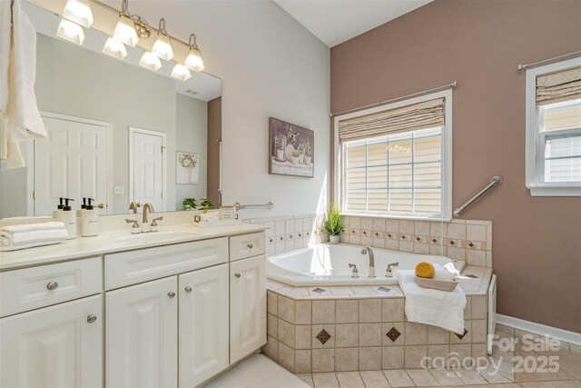 bathroom with a bath, vanity, and tile patterned flooring