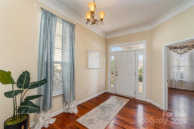 foyer featuring a notable chandelier, crown molding, baseboards, and wood finished floors