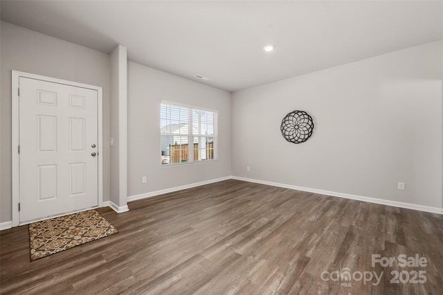 entryway with dark wood-style flooring, visible vents, and baseboards