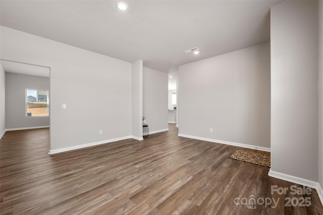 empty room with visible vents, baseboards, wood finished floors, and recessed lighting