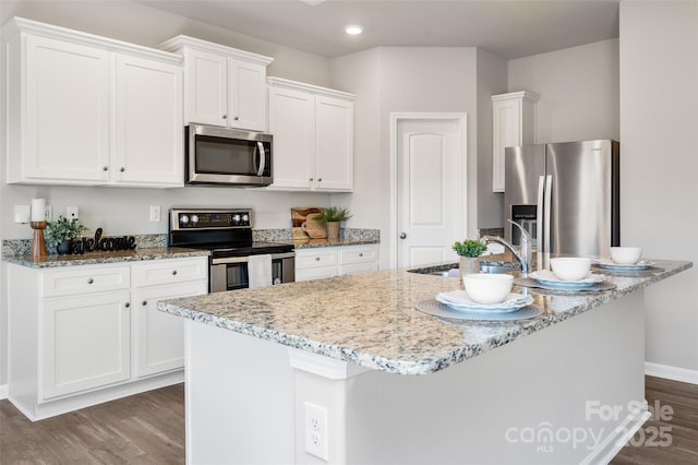 kitchen featuring appliances with stainless steel finishes, white cabinetry, a sink, and dark wood-type flooring