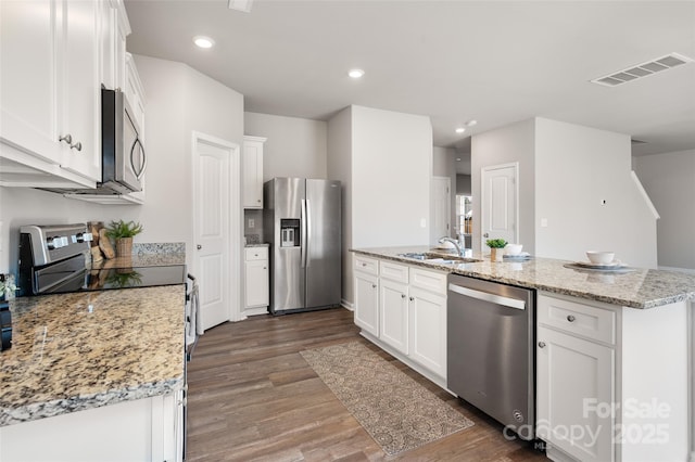 kitchen with stainless steel appliances, dark wood-style flooring, a sink, visible vents, and white cabinets