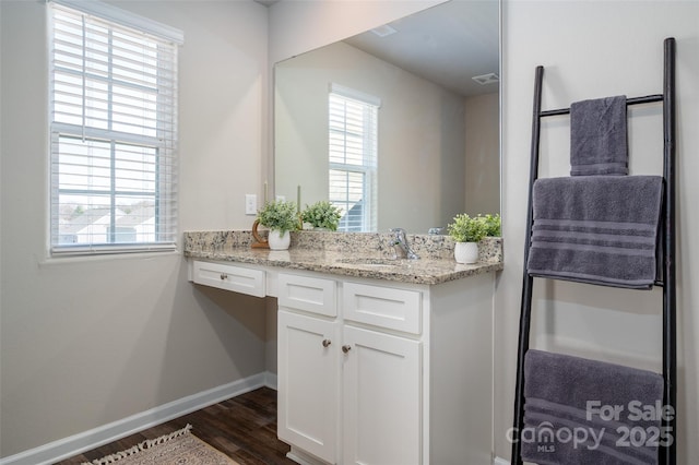 bathroom with visible vents, wood finished floors, a wealth of natural light, and baseboards