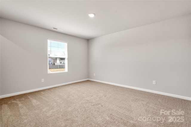 unfurnished room featuring carpet flooring, visible vents, and baseboards