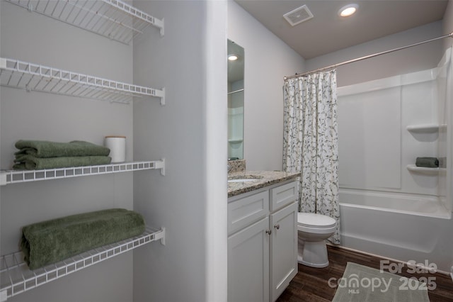 bathroom featuring shower / bath combo, toilet, wood finished floors, vanity, and recessed lighting