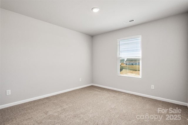 carpeted empty room featuring baseboards and visible vents