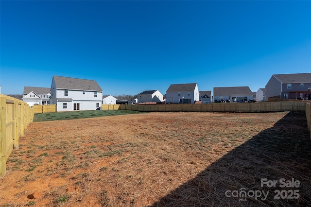 view of yard with a fenced backyard and a residential view