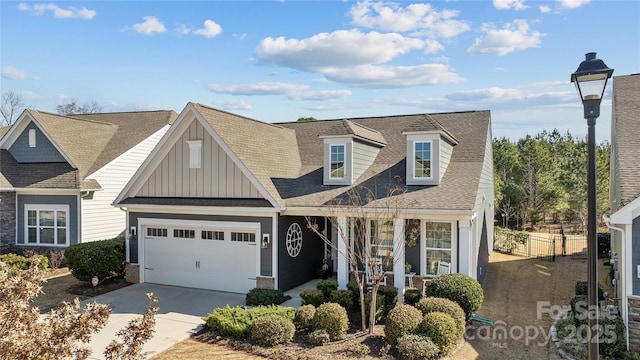 view of front facade with board and batten siding, concrete driveway, a shingled roof, and a garage