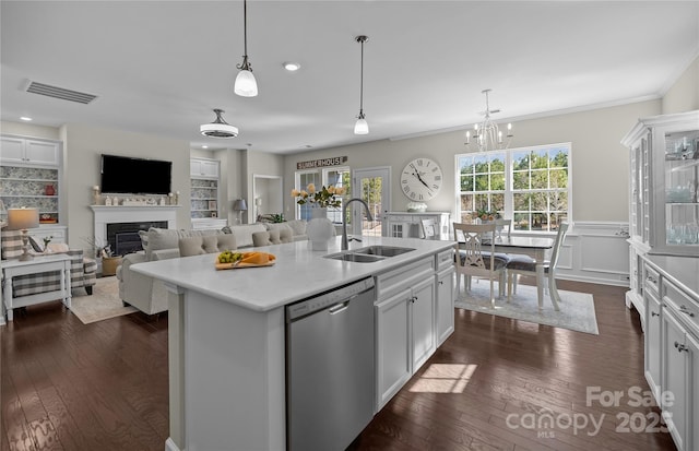 kitchen featuring dark wood finished floors, visible vents, stainless steel dishwasher, a glass covered fireplace, and a sink