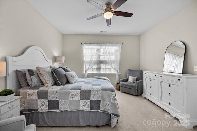 bedroom featuring light colored carpet, ceiling fan, visible vents, and multiple windows