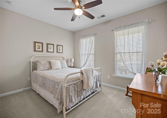 carpeted bedroom with a ceiling fan, visible vents, and baseboards