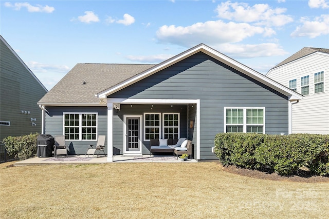 rear view of property with a yard, a patio, and a shingled roof