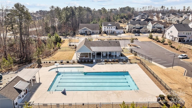 pool with a residential view, fence, and a patio