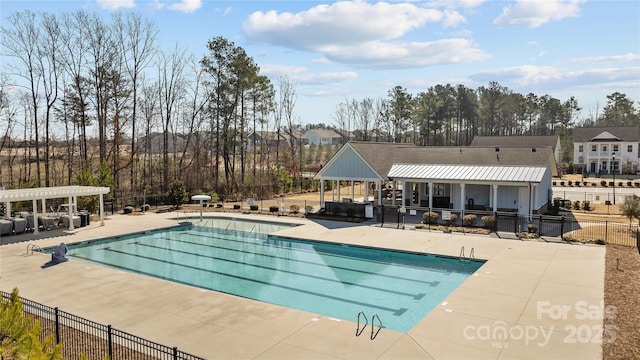 pool with a patio area, fence, and a pergola