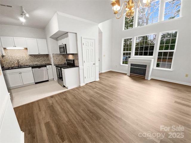 kitchen featuring visible vents, dark countertops, appliances with stainless steel finishes, backsplash, and a notable chandelier