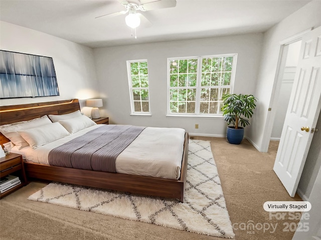 carpeted bedroom with a ceiling fan and baseboards