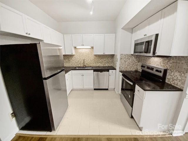 kitchen with appliances with stainless steel finishes, a sink, and white cabinets