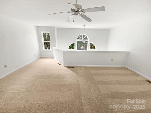 spare room featuring carpet floors, visible vents, baseboards, and a ceiling fan