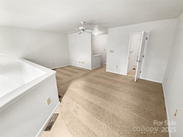 interior space featuring a ceiling fan, carpet, visible vents, and baseboards