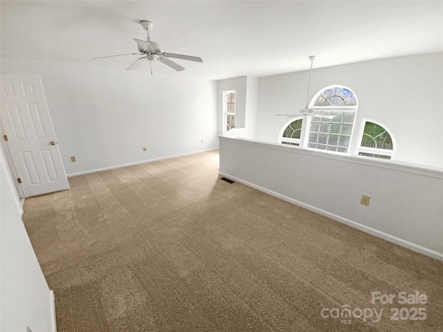 unfurnished room with light carpet, ceiling fan, visible vents, and baseboards