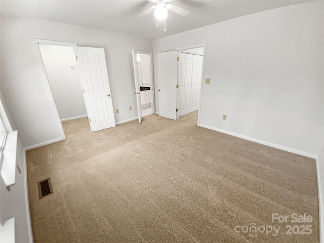 unfurnished bedroom featuring baseboards, a closet, visible vents, and light colored carpet