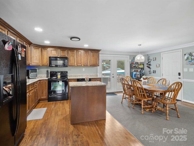 kitchen featuring light wood-style flooring, ornamental molding, french doors, black appliances, and brown cabinetry