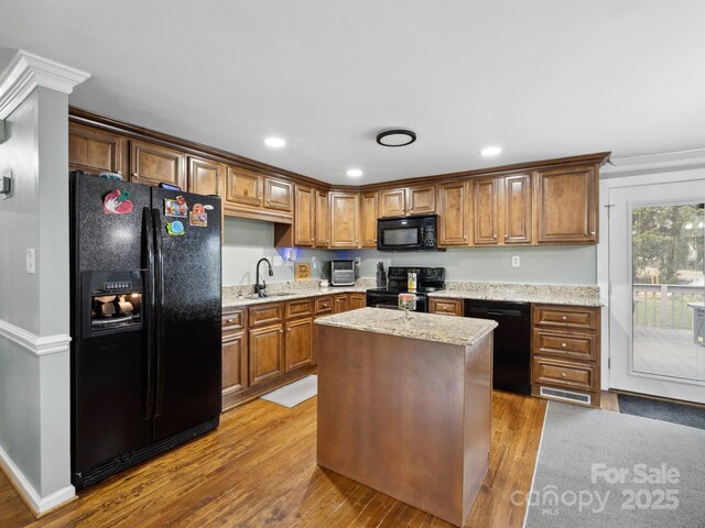2200 Peninsula Ave, Shelby, NC 28150 - kitchen with black appliances, wood finished floors, light stone countertops, recessed lighting, and brown cabinets