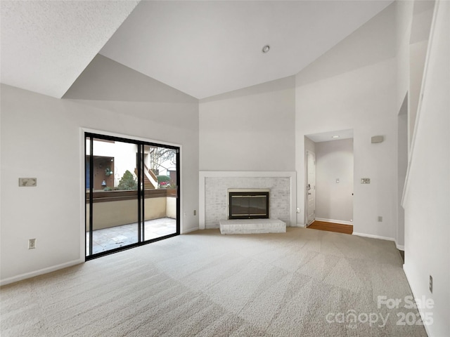 unfurnished living room with carpet floors, a fireplace, high vaulted ceiling, and baseboards