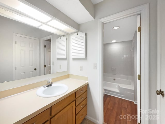 full bath featuring  shower combination, wood finished floors, vanity, and recessed lighting