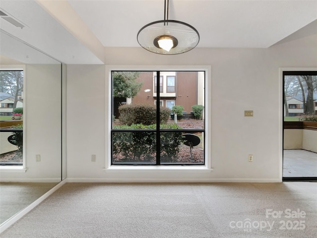 interior space with lofted ceiling, baseboards, visible vents, and carpet flooring