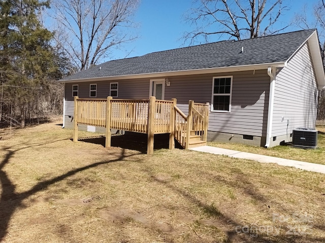 rear view of house featuring a shingled roof, a wooden deck, central AC unit, crawl space, and a yard