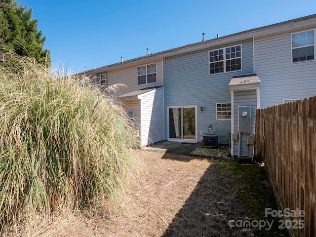 back of property with fence and central air condition unit