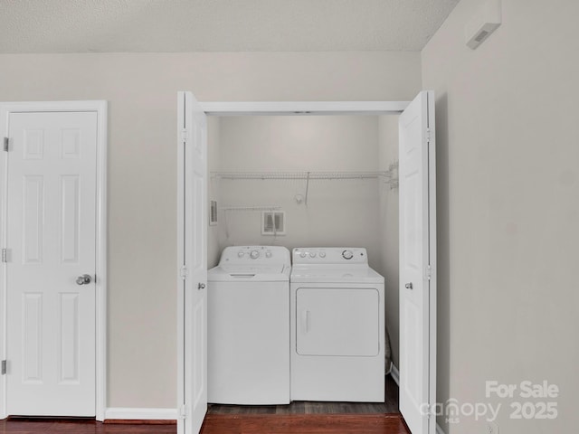 clothes washing area featuring dark wood finished floors, laundry area, and independent washer and dryer